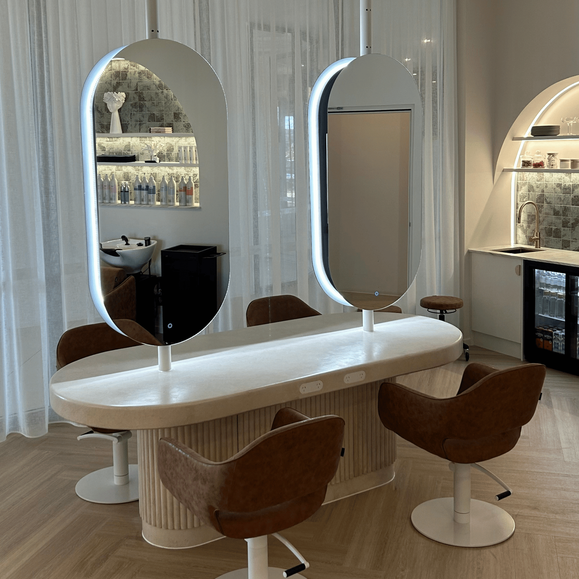 Salon setup with a hairdressing station, mirrors, and chairs.