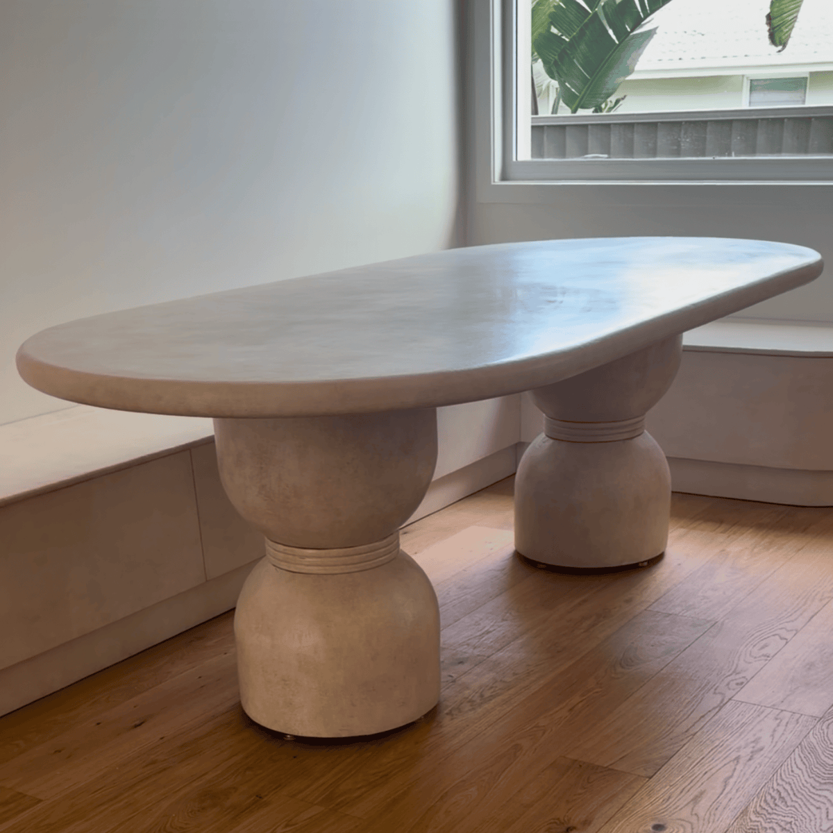 Oxley dining table in Sand Stonewash, in front of bench seating
