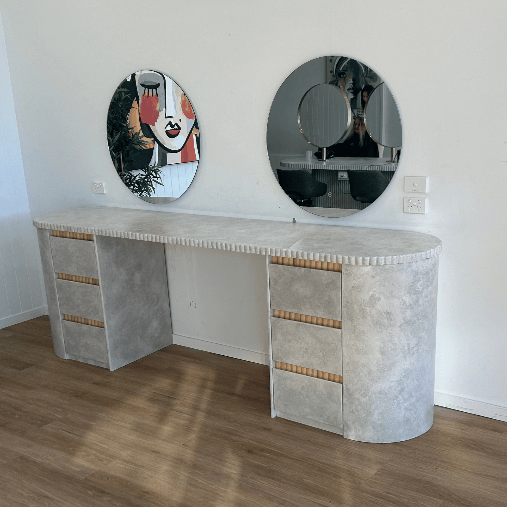 Modern desk with round mirrors on a white wall