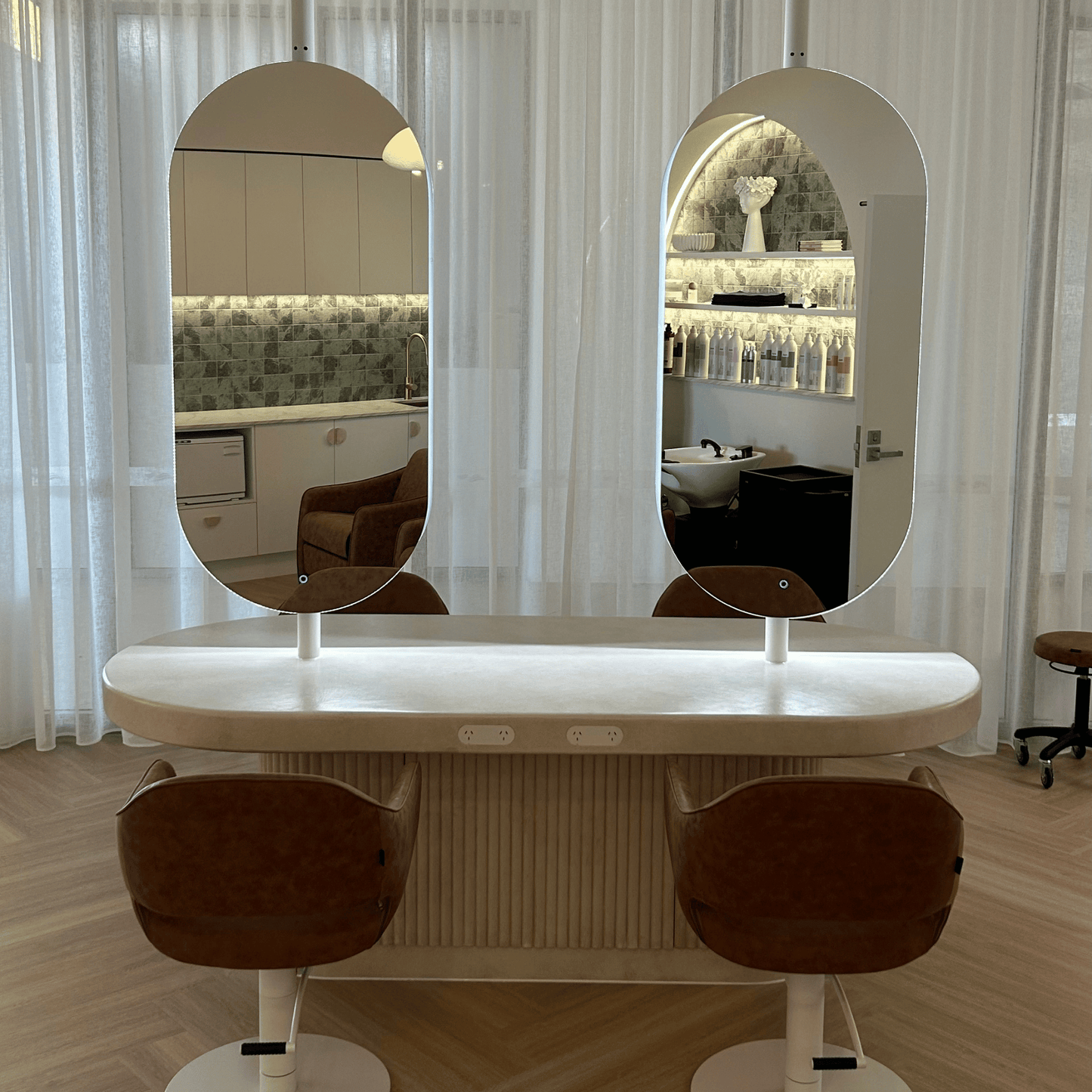 Salon table with two mirrors and two chairs in a room setting.