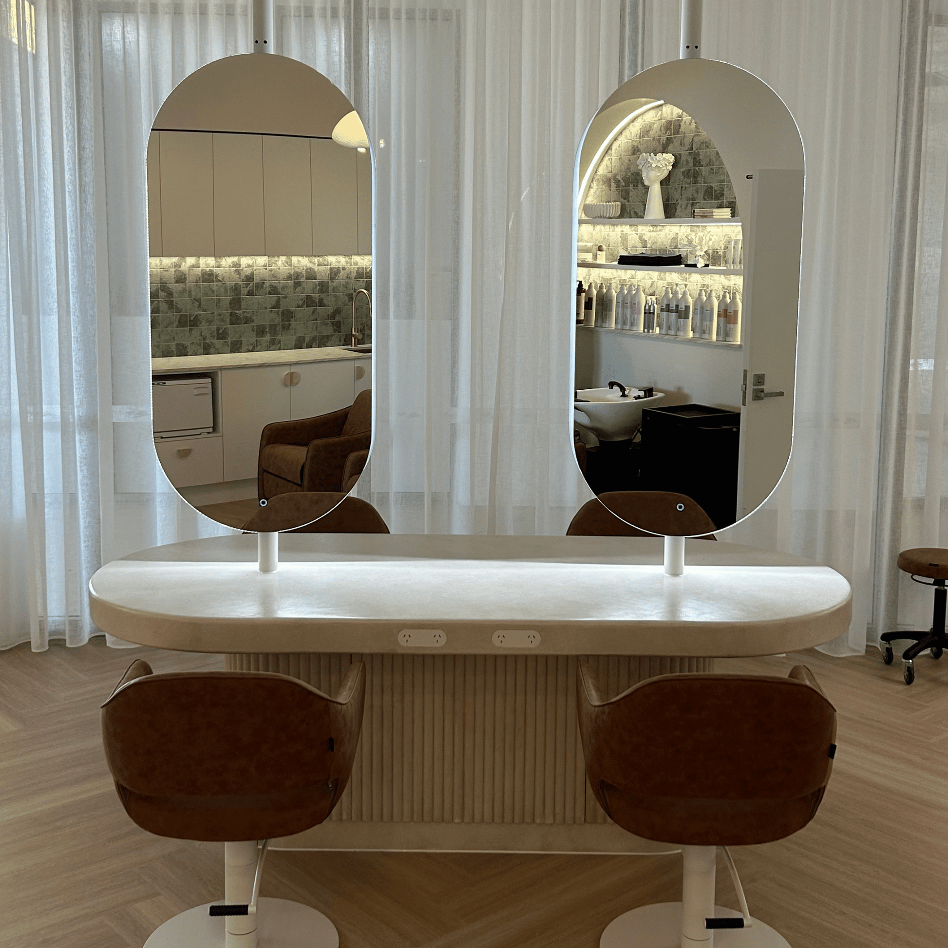 Salon table with two mirrors and two chairs in a room setting.