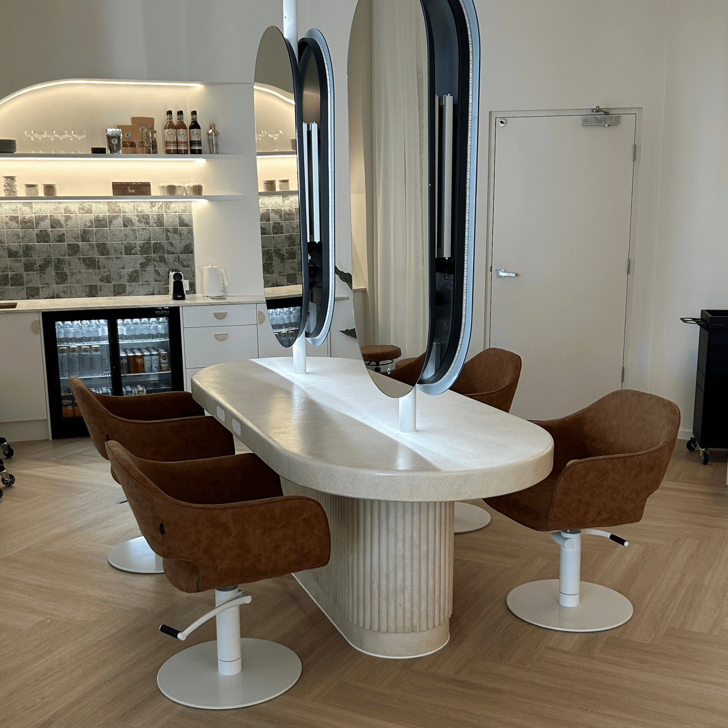 Salon interior with sand stonewash styling table and brown chairs.