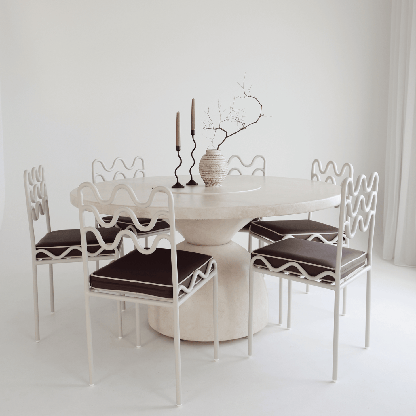lotus round dining table styled with chairs and vases
