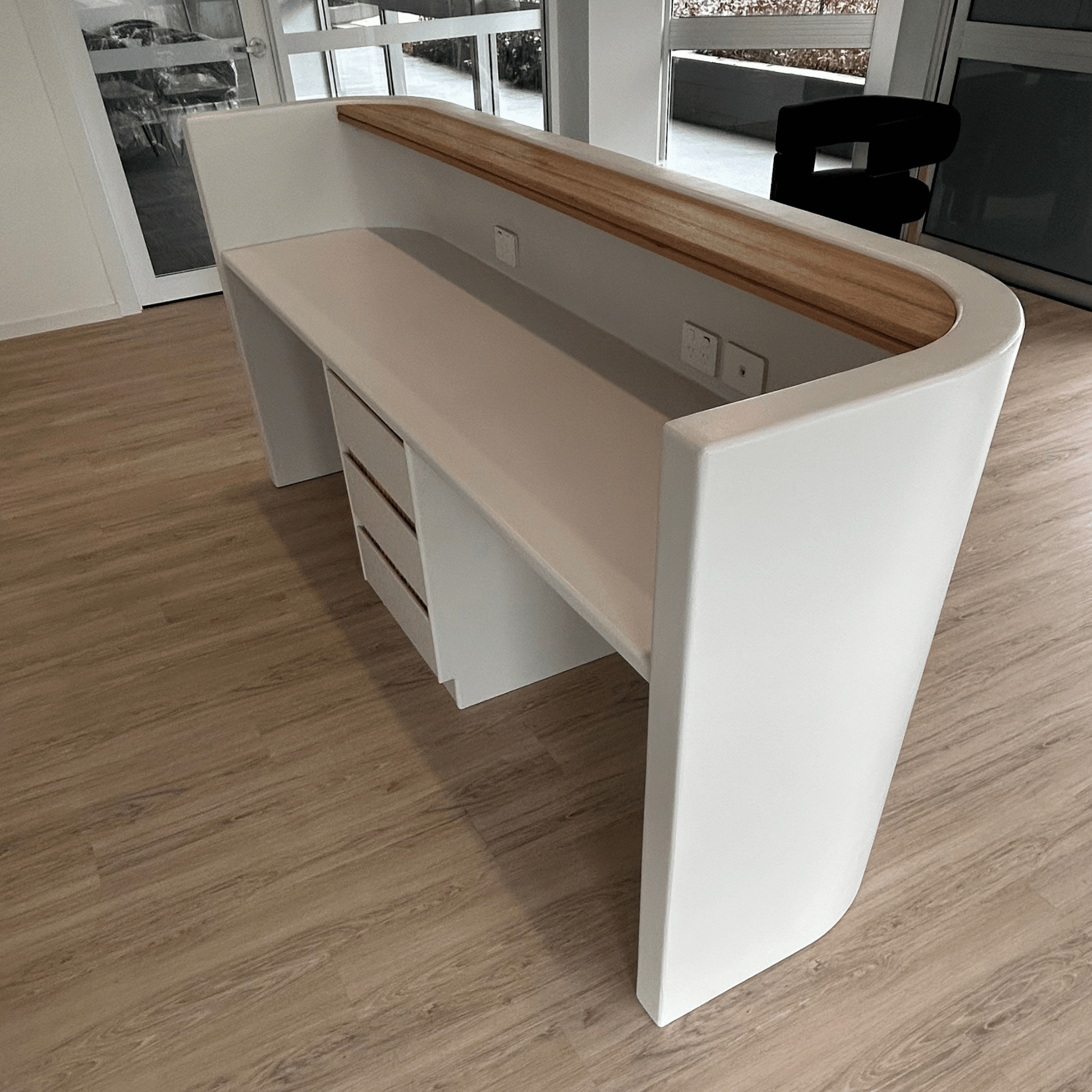 Modern white reception desk with wooden top in a room setting