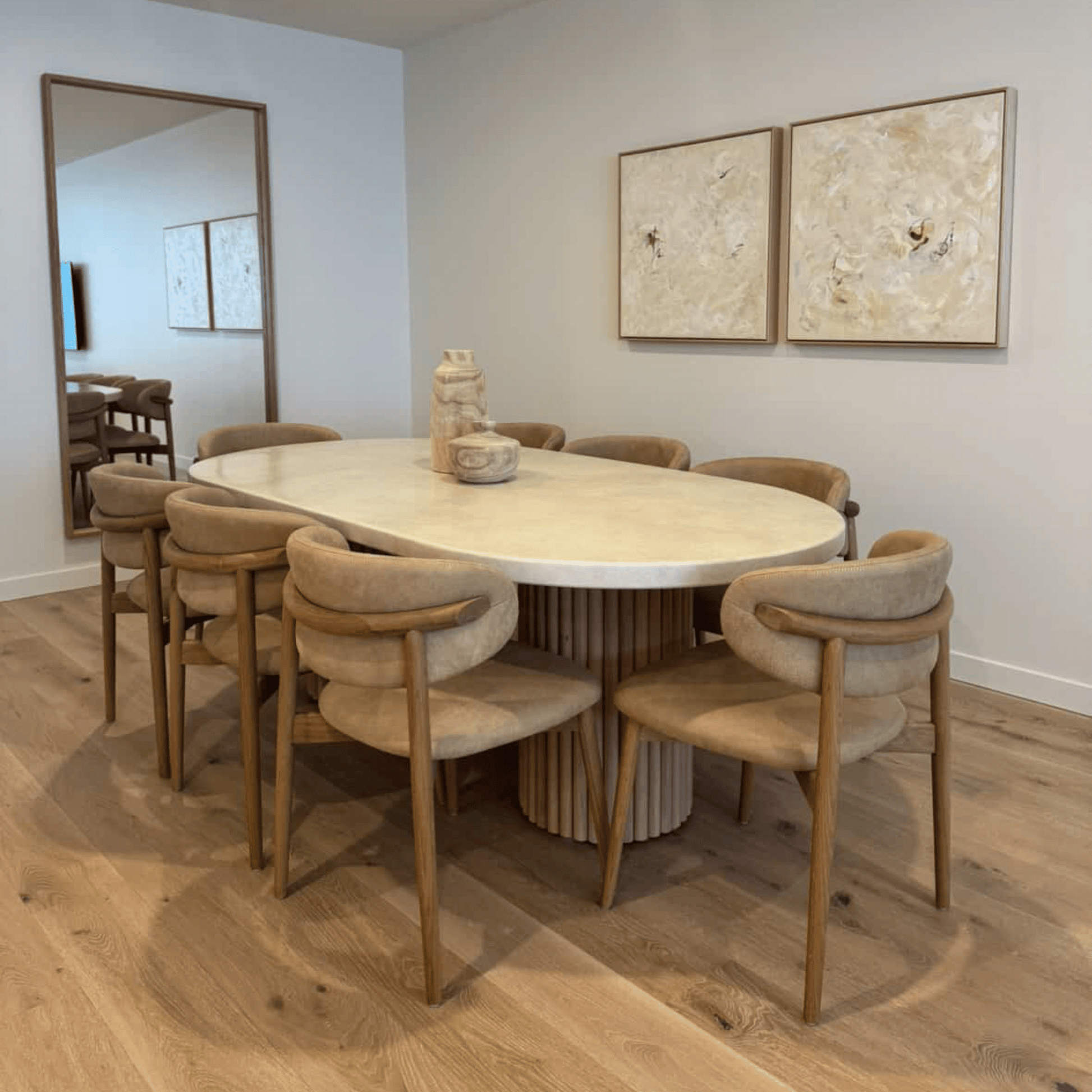 Dining room with a round table and chairs on a wooden floor.