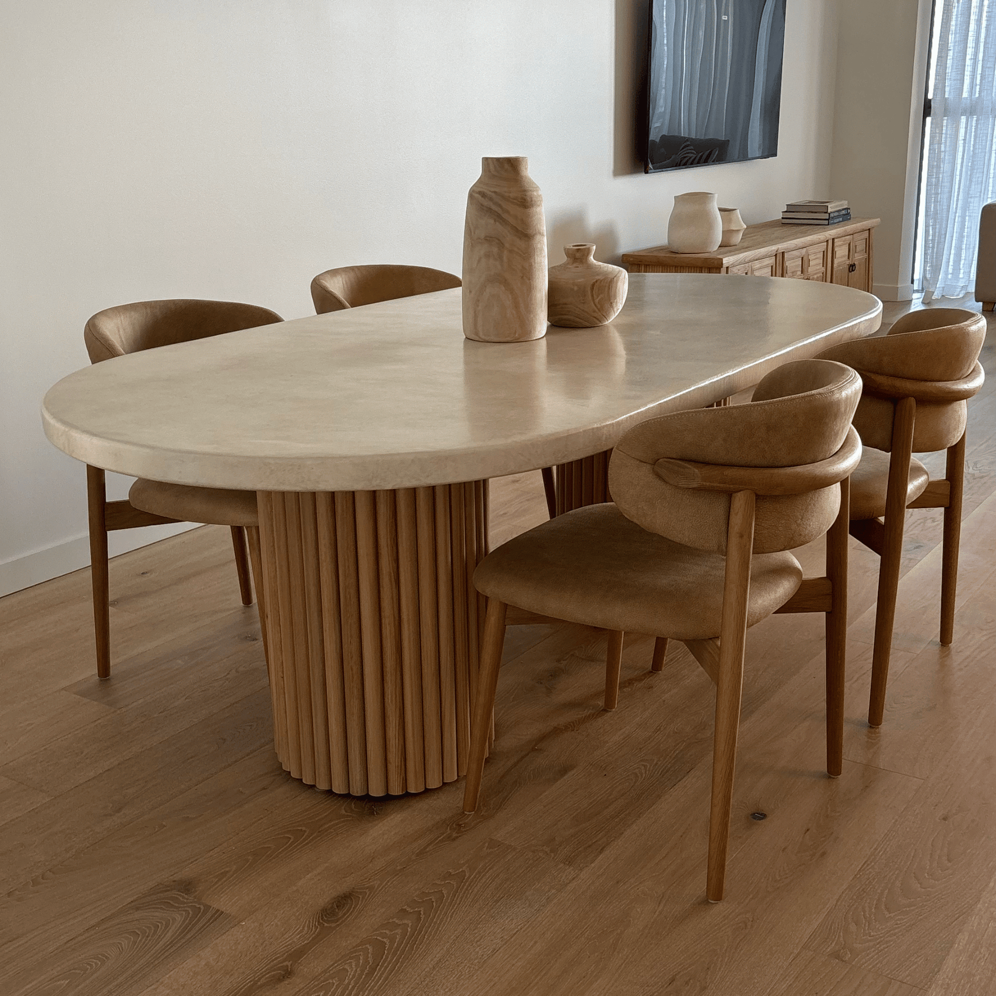 Dining room with a wooden table and chairs on a wooden floor.